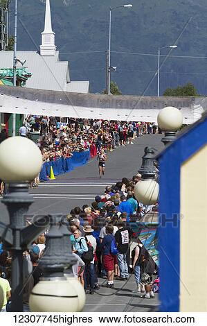 Stock Photograph - Mount Marathon Womens Race winner Holly Brooks comes down 4th Avenue to the finish line and barely finishes in front of 2nd place Christy Marvin. 4th of July, 2014 in Seward, Southcentral Alaska. Summer.. Fotosearch