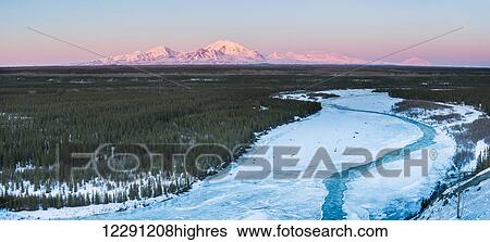 Stock Photograph - Mt. Drum and Mt. Sanford catch alpenglow light behind the Copper River, Southcentral Alaska. Fotosearch