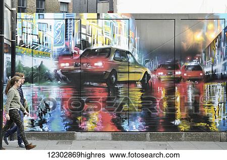 Stock Photograph - Mural near Old Street with people walking by, Shoreditch; London, England. Fotosearch