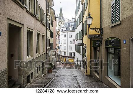 Stock Photo - Narrow cobblestone lane with shops; Zurich, Switzerland. Fotosearch