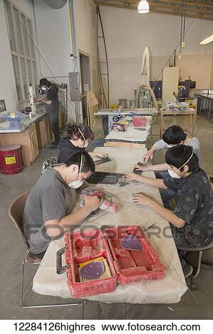 Stock Photograph - Native Alaskan youth wearing respirators use sanders to work on art projects at the Inupiat Heritage Center, Barrow, North Slope, Arctic Alaska. Fotosearch