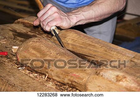 Stock Photo - Native Totem polecarver giving lesson on how to cut the wood with chisel, Juneau, Southeast Alaska. Fotosearch