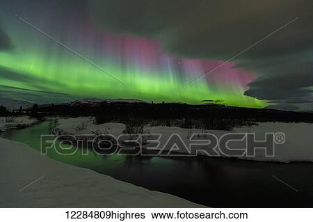 Stock Photograph - Northern Lights over open water in winter near Whitehorse, Yukon Territory, Canada. Fotosearch