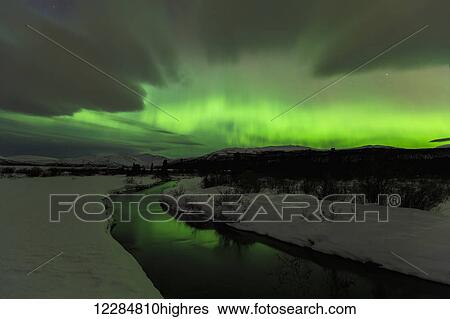 Stock Photograph - Northern Lights over open water in winter near Whitehorse, Yukon Territory, Canada. Fotosearch