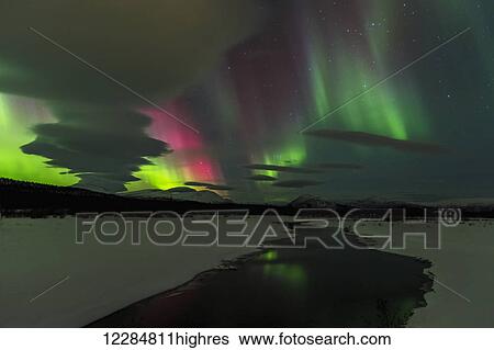 Stock Photograph - Northern Lights over open water in winter near Whitehorse, Yukon Territory, Canada. Fotosearch