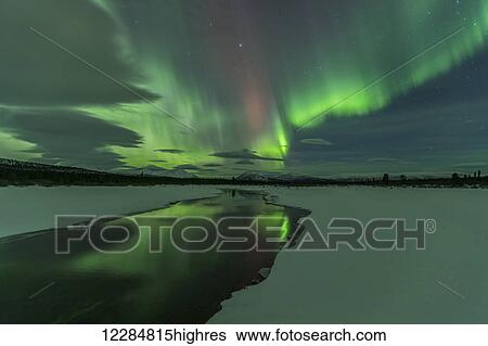 Stock Photograph - Northern Lights over open water in winter near Whitehorse, Yukon Territory, Canada. Fotosearch
