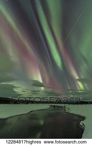 Stock Photograph - Northern Lights over open water in winter near Whitehorse, Yukon Territory, Canada. Fotosearch