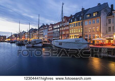 Nyhavn, the famous waterfront canal in Copenhagen with colourful seventeenth and eighteenth century townhomes lining the canal at dusk; Copenhagen, Denmark View Large Photo Image Stock Photograph - Nyhavn, the famous waterfront canal in Copenhagen with colourful seventeenth and eighteenth century townhomes lining the canal at dusk; Copenhagen, Denmark. Fotosearch