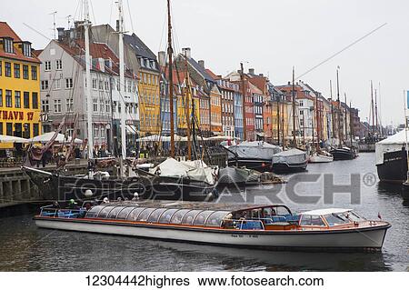 Nyhavn, the famous waterfront canal in Copenhagen with colourful seventeenth and eighteenth century townhomes lining the canal at dusk; Copenhagen, Denmark View Large Photo Image Stock Photograph - Nyhavn, the famous waterfront canal in Copenhagen with colourful seventeenth and eighteenth century townhomes lining the canal at dusk; Copenhagen, Denmark. Fotosearch