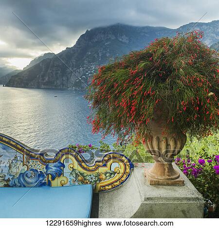 Ornate and colourful railing with a blossoming plant and a view of the Amalfi coast; Amalfi, Italy View Large Photo Image Stock Photograph - Ornate and colourful railing with a blossoming plant and a view of the Amalfi coast; Amalfi, Italy. Fotosearch