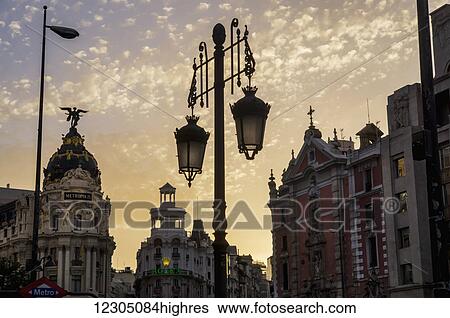 Stock Photograph - Ornate lamp post and historic buildings at dusk; Madrid, Spain. Fotosearch