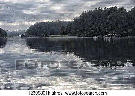 Stock Photograph - Overcast clouds reflected in the Kodiak harbor, Southcentral Alaska, USA. Fotosearch
