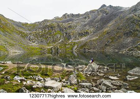 Pair of hikers stop to enjoy the view at Gold Cord Lake in Hatcher Pass. Southcentral Alaska. Summer. View Large Photo Image Stock Photograph - Pair of hikers stop to enjoy the view at Gold Cord Lake in Hatcher Pass. Southcentral Alaska. Summer.. Fotosearch