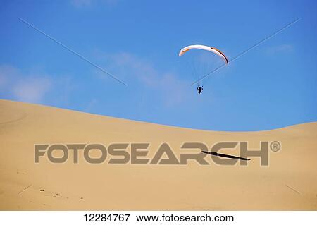 Parachuter making a landing in the desert; Swakopmund, Namibia View Large Photo Image Stock Photo - Parachuter making a landing in the desert; Swakopmund, Namibia. Fotosearch
