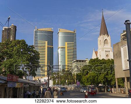 Picture - Pedestrians, St. Joseph's Cathedral, and twin buildings against a blue sky; Dar es Salaam, Tanzania. Fotosearch