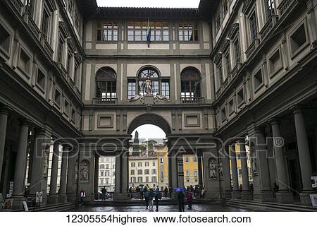 Stock Photograph - Pedestrians walking in the courtyard of a building with columns; Florence, Italy. Fotosearch