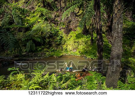 Stock Photograph - People bathing in thermal waters at Monumento Natural Caldeira Velha, National Park; Sao Miguel, Azores, Portugal. Fotosearch