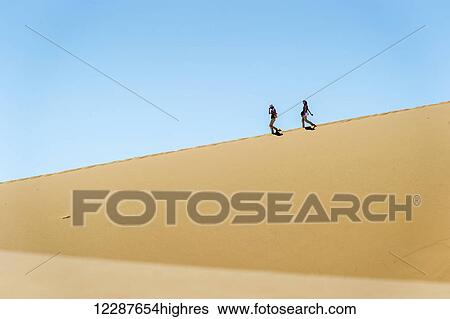 People walking through the desert; Sossusvlei, Namibia View Large Photo Image Stock Photograph - People walking through the desert; Sossusvlei, Namibia. Fotosearch