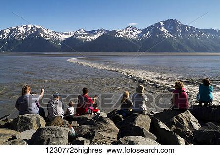 Stock Photograph - People watching the bore tide in Turnagain Arm at Mile 94 of the Seward Highway. Summer. Southcentral Alaska.. Fotosearch