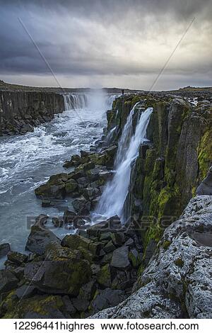 Stock Photograph - Person photographing Selfoss in northern Iceland; Iceland. Fotosearch