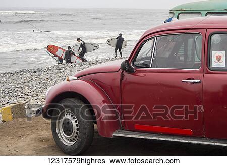 Peruvian surfers hit the rocky Pacific Ocean in the Mira Flores part of Lima on an overcast autumn day with a Volkswagen bug in the foreground; Lima, Peru View Large Photo Image Stock Photograph - Peruvian surfers hit the rocky Pacific Ocean in the Mira Flores part of Lima on an overcast autumn day with a Volkswagen bug in the foreground; Lima, Peru. Fotosearch