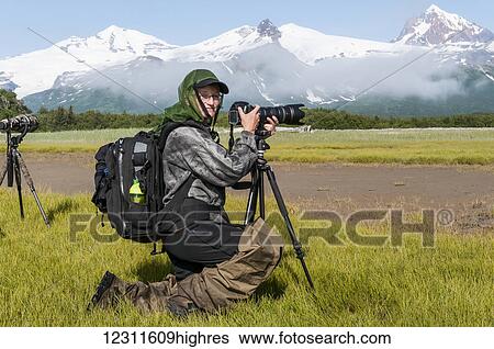 Photographer in a scenic landscape at Hallo Bay, Katmai National Park, Southwest Alaska, USA View Large Photo Image Stock Photograph - Photographer in a scenic landscape at Hallo Bay, Katmai National Park, Southwest Alaska, USA. Fotosearch