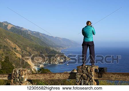 Stock Photograph - Photographer shooting landscape and Pacific Ocean along State Route 1; California, United States of America. Fotosearch