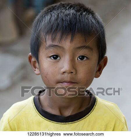 Stock Photograph - Portrait of a young boy with a dirty face; Paro, Bhutan. Fotosearch