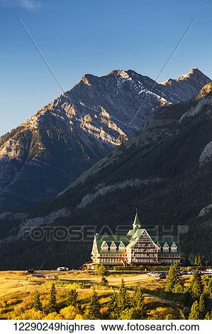 Prince of Wales hotel on a hilltop at sunrise with mountain and blue sky in the background; Waterton, Alberta, Canada View Large Photo Image Stock Photograph - Prince of Wales hotel on a hilltop at sunrise with mountain and blue sky in the background; Waterton, Alberta, Canada. Fotosearch