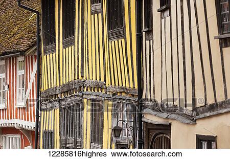 Stock Photograph - Quaint, colourful and half-timbered houses in an English village; Lavenham, Suffolk, England. Fotosearch
