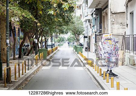 Stock Photograph - Rack of books on display on the side of a narrow street; Thessaloniki, Greece. Fotosearch
