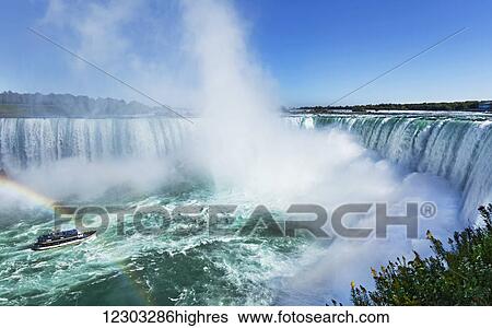 Stock Photograph - Rainbow over Maid of The Mist tour boat; Niagara Falls, Ontario, Canada. Fotosearch