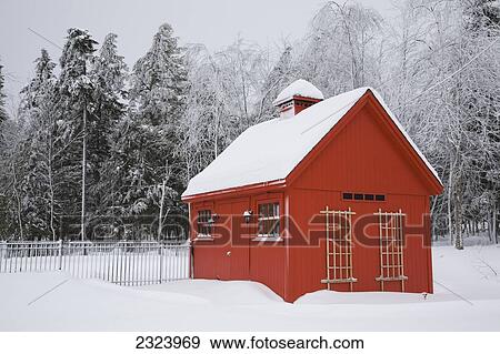 Red Barn Style Storage Shed With Frost And Snow Covered Trees In