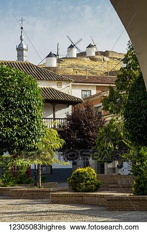 Stock Photograph - Residential buildings with windmills on the hilltop; Consuegra, Castile-La Mancha, Spain. Fotosearch