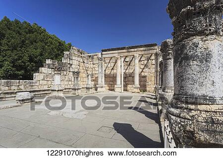 Stock Photograph - Ruins of a late fourth century AD synagogue with columns and a wall against a blue sky; Capernaum, Israel. Fotosearch