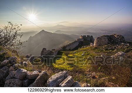 Ruins of a stone wall and buildings with a sunburst and mountains; Corinth, Greece View Large Photo Image Stock Photograph - Ruins of a stone wall and buildings with a sunburst and mountains; Corinth, Greece. Fotosearch