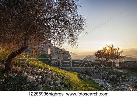Stock Photograph - Ruins of stone wall and building at sunset; Corinth, Greece. Fotosearch