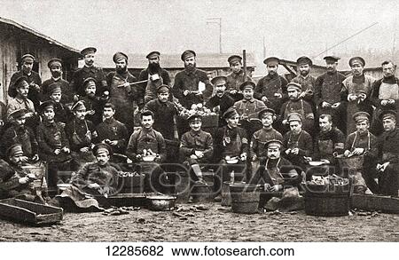 Stock Image - Russian prisoners at Cottbus, Germany, peeling potatoes, which were their staple diet, during World War One. From The Pageant of the Century, published 1934. Fotosearch
