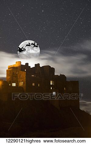 Santa in his sleigh and reindeer silhouetted in the starry sky in front of the moon over buildings; Bamburgh, Northumberland, England View Large Photo Image Stock Photograph - Santa in his sleigh and reindeer silhouetted in the starry sky in front of the moon over buildings; Bamburgh, Northumberland, England. Fotosearch