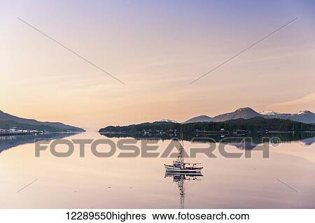Scenic sunrise view of a small fishing boat reflecting in Ketchikan harbor, Southeast Alaska, Spring View Large Photo Image Stock Photograph - Scenic sunrise view of a small fishing boat reflecting in Ketchikan harbor, Southeast Alaska, Spring. Fotosearch