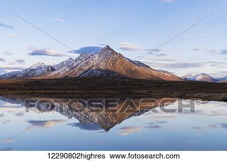 Stock Photograph - Scenic view of a rugged mountain peak reflecting in a lake, Tombstone Territorial Park, Yukon Territory, Canada, Autumn. Fotosearch