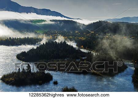Stock Photograph - Scenic view of fog over the Yukon River near Whitehouse, Yukon Territory, Canada. Fotosearch