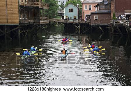Stock Photograph - Sea Kayakers along Creek Street, Ketchikan, Southeast Alaska, Summer. Fotosearch