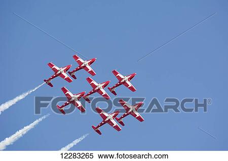 Seven red military aircraft fly in formation against blue sky; Lethbridge, Alberta, Canada View Large Photo Image Stock Photography - Seven red military aircraft fly in formation against blue sky; Lethbridge, Alberta, Canada. Fotosearch