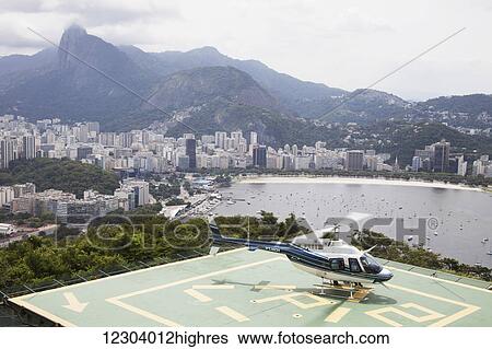 Stock Photograph - Sightseeing helicopter at top of Sugarloaf Mountain, looking to Botafogo Bay; Rio de Janeiro, Brazil. Fotosearch
