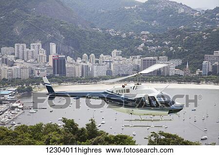 Stock Photograph - Sightseeing helicopter seen from Sugarloaf Mountain, looking to Botafogo Bay; Rio de Janeiro, Brazil. Fotosearch