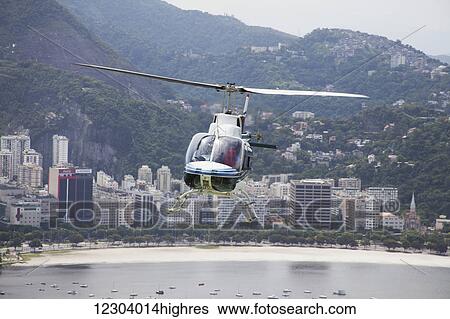 Stock Photograph - Sightseeing helicopter seen from Sugarloaf Mountain, looking to Botafogo Bay; Rio de Janeiro, Brazil. Fotosearch