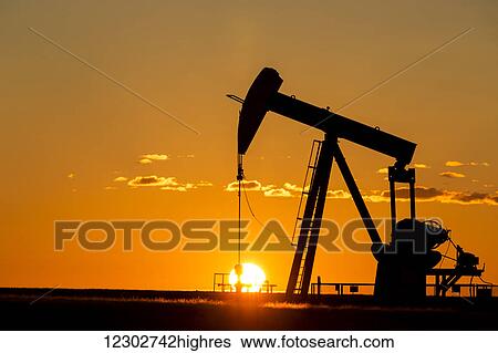 Silhouette of a pump jack at sunrise with orange glow in the sky and clouds; Acme, Alberta, Canada View Large Photo Image Stock Photograph - Silhouette of a pump jack at sunrise with orange glow in the sky and clouds; Acme, Alberta, Canada. Fotosearch
