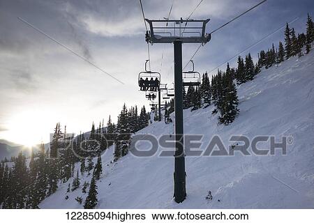 Skiers On A Ski Lift At Sunset Lake Louise Alberta Canada Stock