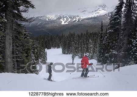 Stock Photograph - Skiing down resort ski hill; Whistler, British Columbia, Canada. Fotosearch